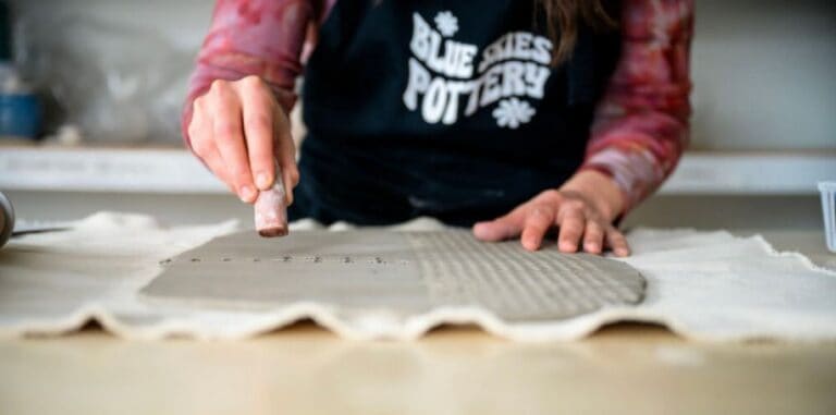Child shaping clay during pottery class for students with disabilities.